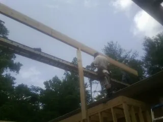 Carpenter setting a ridge beam over a new addition frame — Ice Dam Removal by Roofing Brothers in Lexington