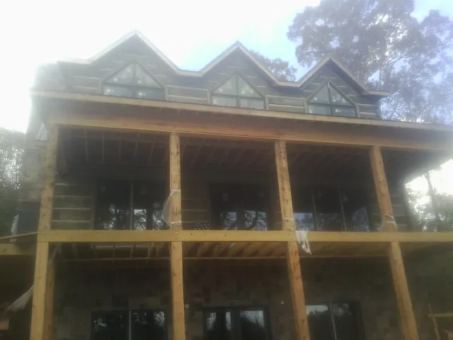 Dormers and porch framing on a large log home under construction — Roof Coating work by our crew in Lexington